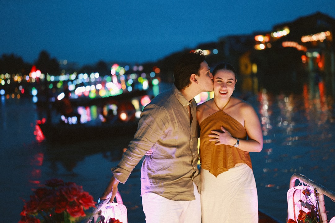 Couple on a boat at night with city lights