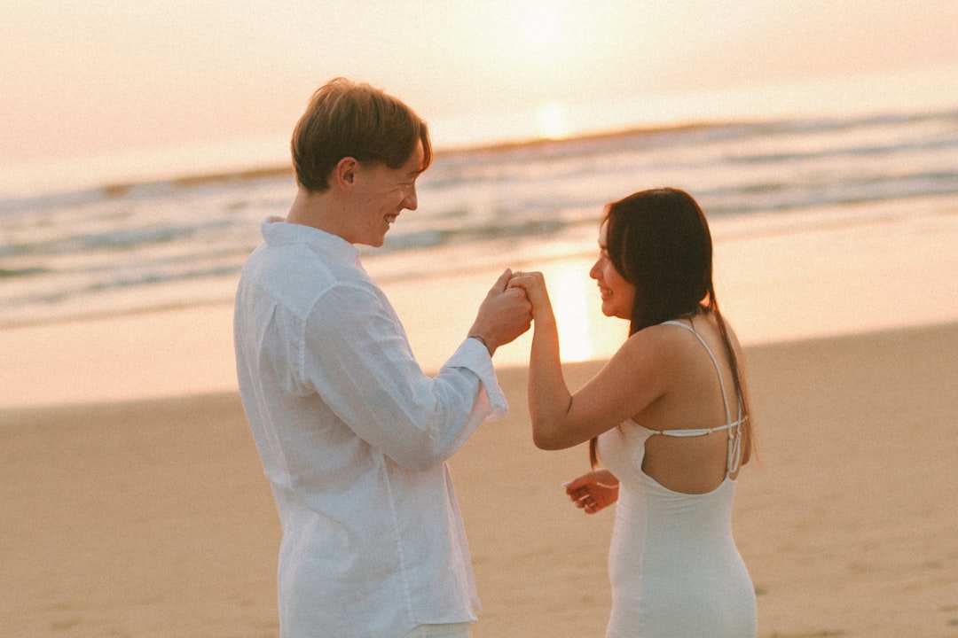 Couple holding hands on a beach at sunset