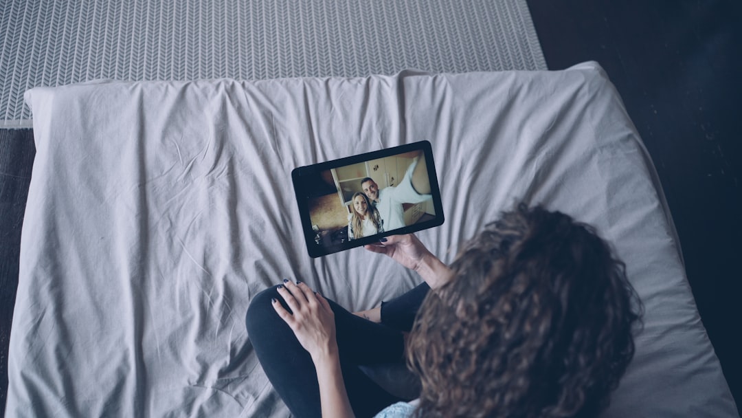 Woman watching video on tablet in bed.